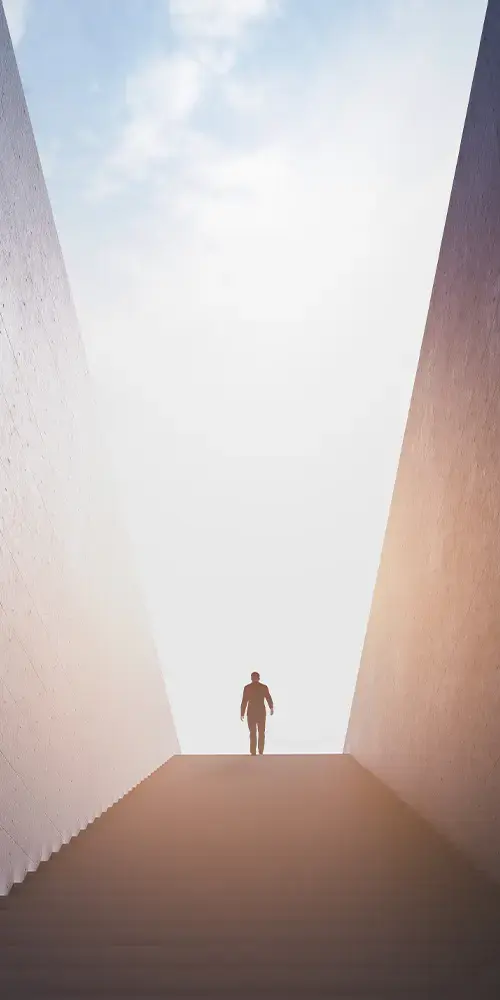 Person steht am Ende einer Treppe, hinter ihm scheint die Sonne